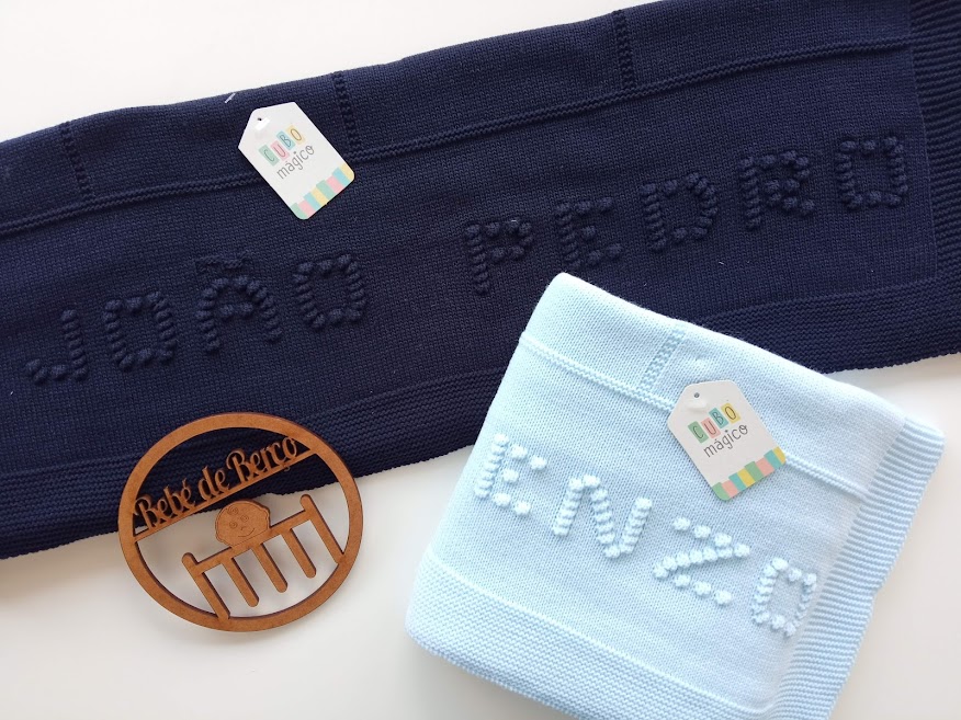 Duas mantas de bebé azuis com nomes em relevo e etiquetas da marca BEBE DE LUXO