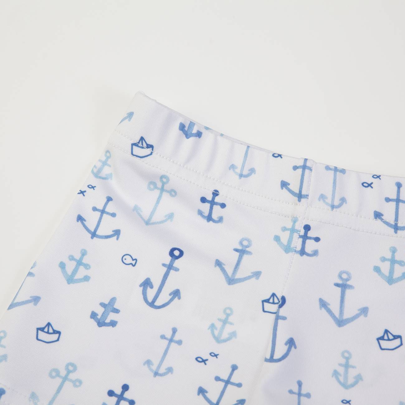Roupa infantil branca com padrão de âncoras e barcos azuis