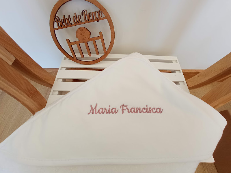Toalha branca com nome bordado e banco com decoração em madeira