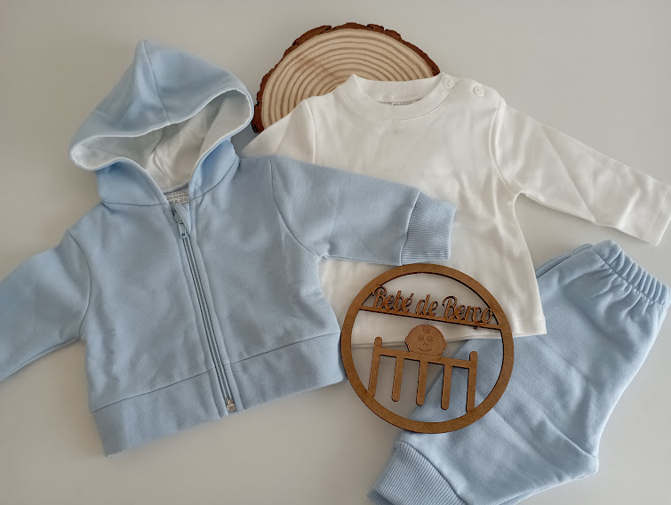 Conjunto de roupa de bebé azul claro e branca com base e placa de madeira