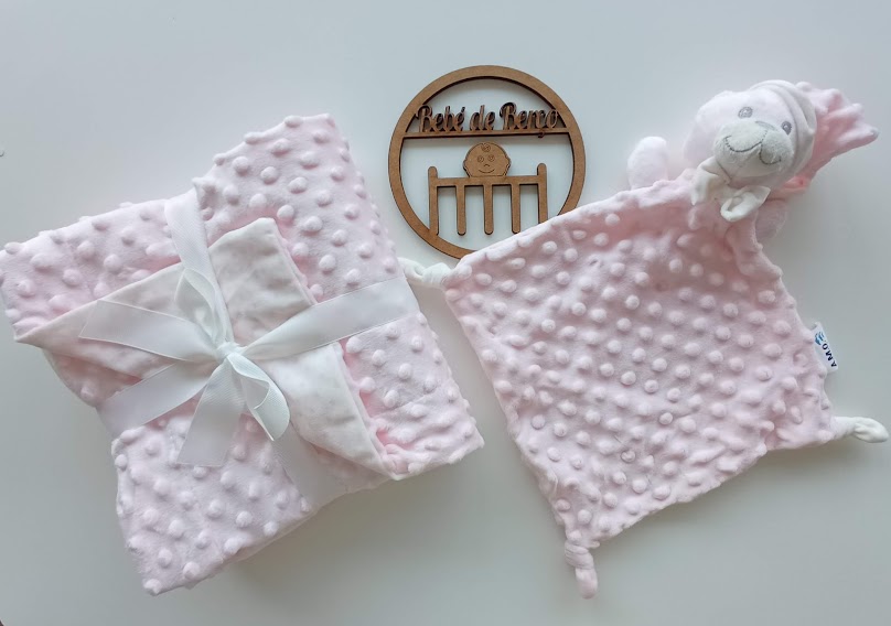 mantas e brinquedo de pelúcia rosa para bebés com textura bolha, texto Hotel da Beija em objeto de madeira