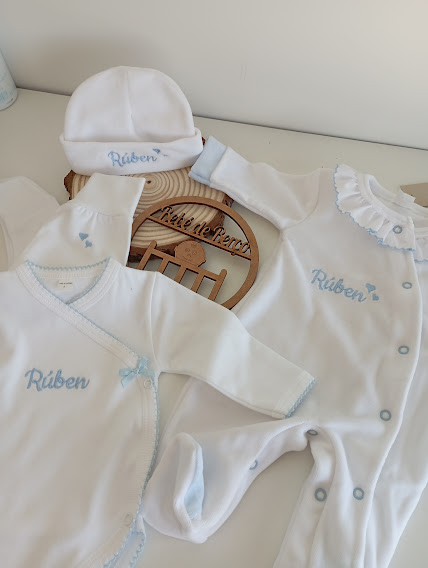 Conjunto de roupa de bebé branca com detalhes azuis e nome Rúben bordado