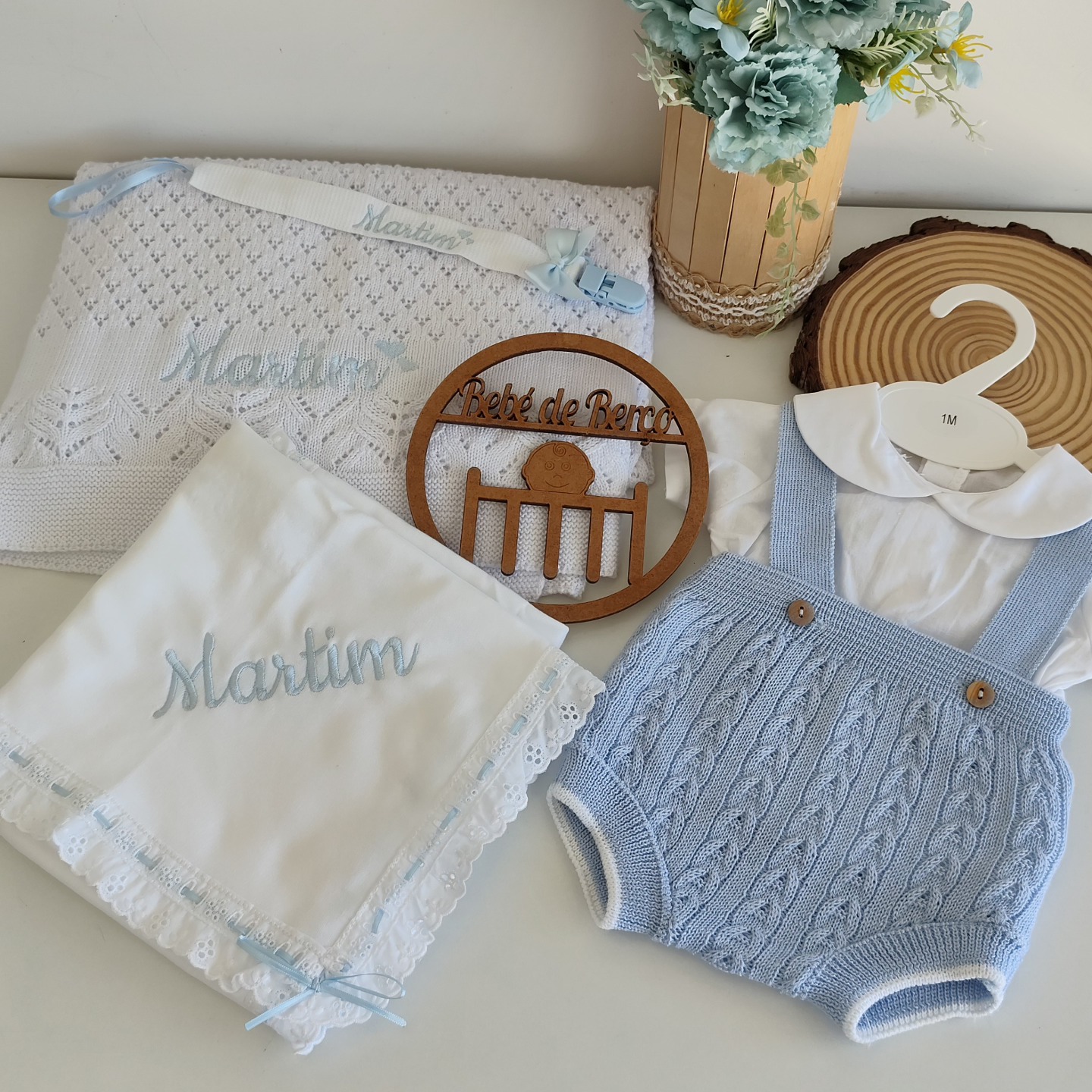 Conjunto bebé com manta branca, babete com bordado Martim, macacão azul de malha e camisa branca