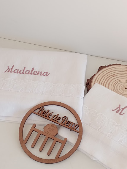 Toalhas brancas com bordado rosa Madalena e ornamento de madeira retangular circular