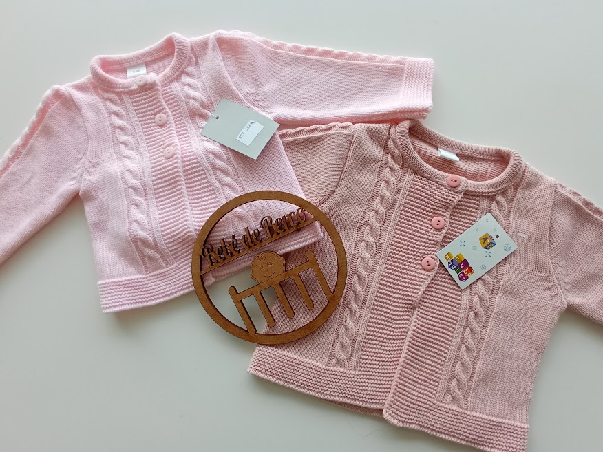 Casacos bebé rosa claro e rosa com padrão de trança e botões, etiquetas e placa em madeira