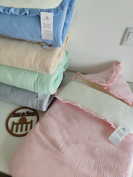 Conjunto de mantas coloridas de algodão com etiquetas brancas, em superfície branca