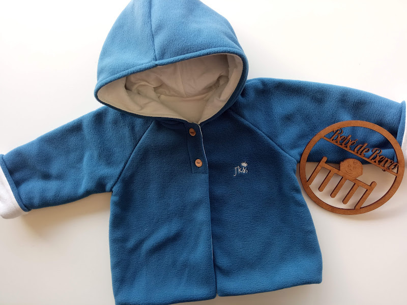 Casaco azul polar com capuz bege e logótipo de madeira 'Kreativ'