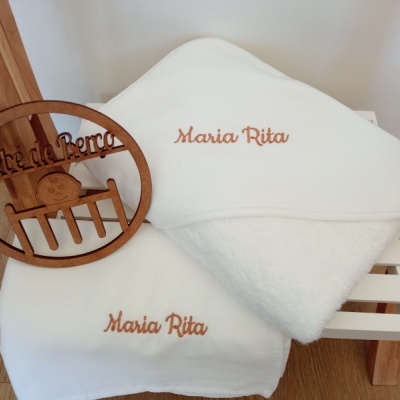Toalhas brancas com nome bordado e placa de madeira com texto