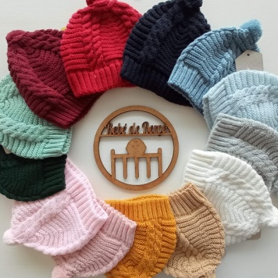 Conjunto de gorros de lã coloridos em círculo com placa de madeira ao centro