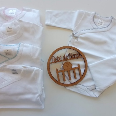 Conjuntos de roupa branca para bebé com detalhes em azul e placa de madeira 'Bébé de Rentrée'