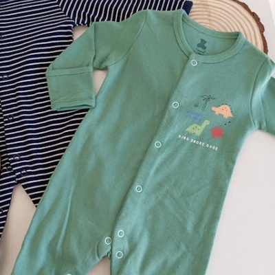 Dois pijamas de bebé, azul às riscas e verde com estampado de dinossauros