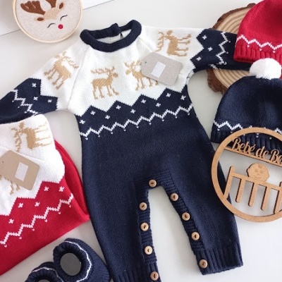 Macacão de malha para bebé com padrão de renas e botões, gorros e patucos ao lado