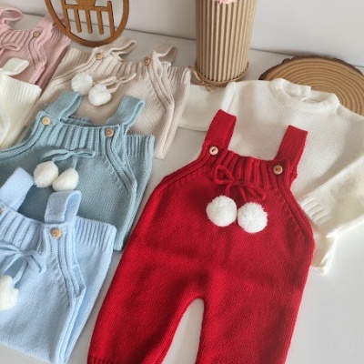 Conjunto de jardineira e camisola de bebé em malha colorida com pompons.