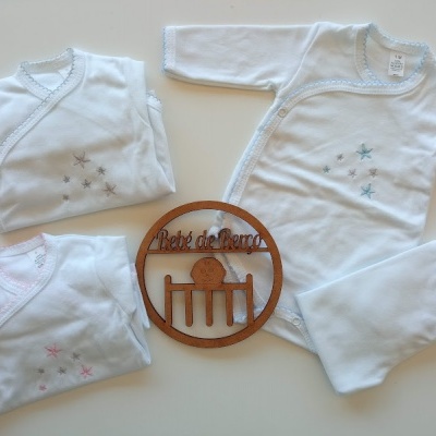 Conjunto de roupa de bebé branca com estrelas e objeto decorativo de madeira