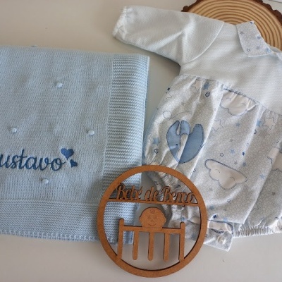 Cobertor azul bordado 'Gustavo' e roupinha de bebé com padrão de elefantes