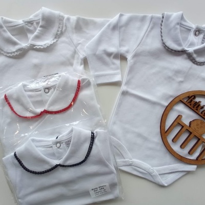 Bodies brancos para bebé com golas bordadas de várias cores, alguns embalados