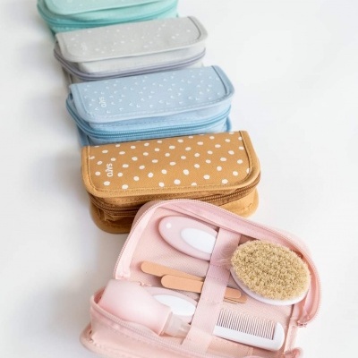 Conjunto de estojos de cuidados infantis com utensílios para bebé, coloridos e em tecido.