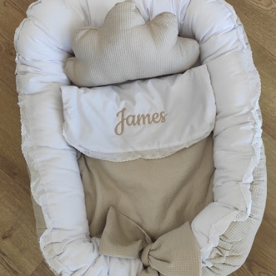 Ninho de bebé bege e branco com almofada de nuvem e bordado James