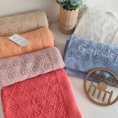 Cobertores em algodão coloridos com padrão geométrico e vaso de flores