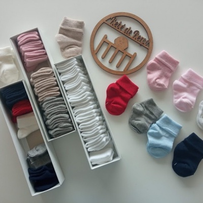 Meias de várias cores organizadas em caixas com círculo de madeira gravado 'Kids de Room'