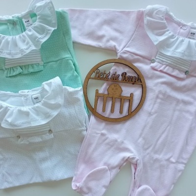 Três macacões de bebé verde, branco e rosa com gola branca decorativa e bordado, com placa de madeira 'Peito de Anjo'