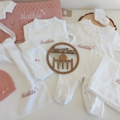 Conjunto de roupa de bebé com nome Matilde bordado, em branco e rosa, com várias peças e manta.
