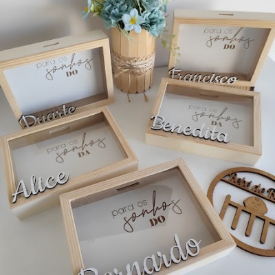 Caixas de madeira com nomes e texto para os sonhos DO, com vaso de flores azuis e brancas ao centro