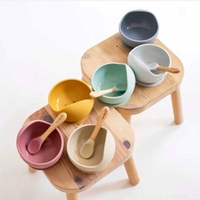 Seis tigelas cerâmicas coloridas com colheres de madeira em mesas de madeira clara