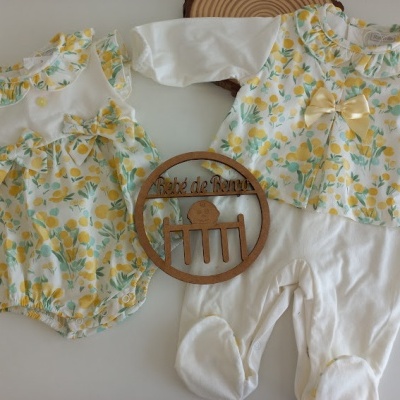 Conjuntos de roupa de bebê com padrão floral amarelo e branco e decoração de madeira com texto Pé de mesa