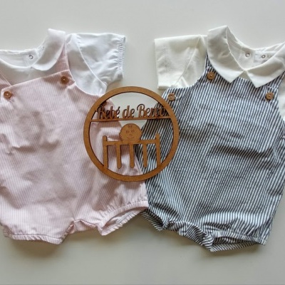 Dois macacões de bebé às riscas rosa e cinzento com camisas brancas e logotipo de madeira Débô de Berço