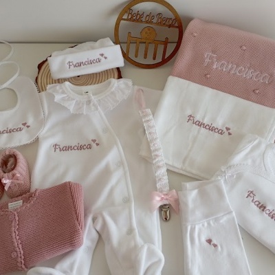 Conjunto de roupa e acessórios de bebé branco e rosa com nome Francisca bordado.