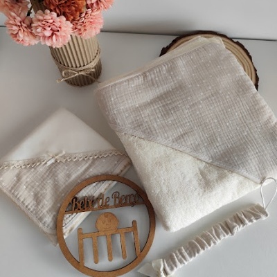 Conjunto de toalha, toalhita, prende-chuchas e placa de madeira 'bebé de berço' com vaso de flores artificiais.