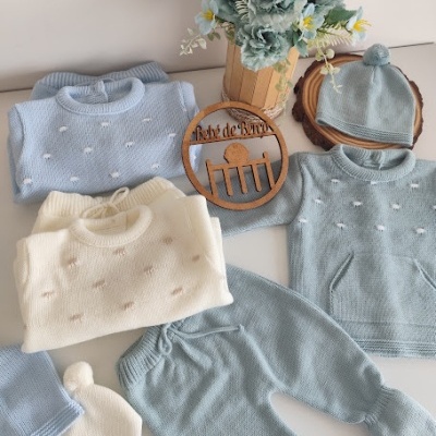 Conjunto de roupa de bebé em malha azul, branco e cinzento com flores artificiais e ornamento de madeira