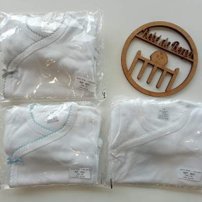 Três bodies de bebé brancos embalados com costuras coloridas e ornamento de madeira com texto