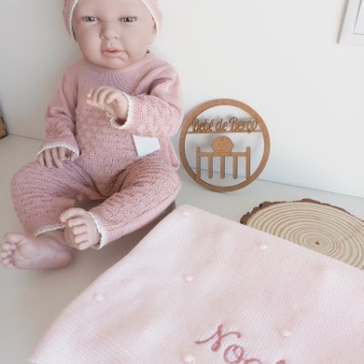 Boneco de bebé com roupa e gorro rosa e manta bordada com o nome Noah