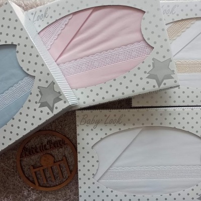 Conjunto de quatro fraldas para bebé em caixas coloridas em azul, rosa, bege e branco com detalhes de renda.