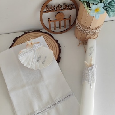 Cachecol, anel em concha, vela branca com texto e vaso decorativo com flores artificiais