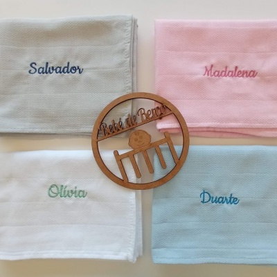 Toalhas de bebé em quatro cores com nomes bordados e ornamento de madeira no centro