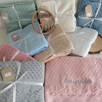 Mantinhas de bebé em várias cores e padrões tricotados, com nome bordado e etiqueta