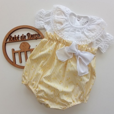 Body de bebé branco com gola rendada e parte inferior amarela com laço branco