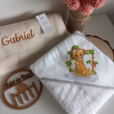 Toalha com bordado Simba, manta com nome Gabriel, flores cor-de-rosa e placa decorativa