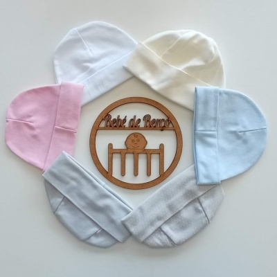 Cinco gorros de bebé em várias cores dispostos em círculo com uma placa de madeira 'Bébé de Reros' ao centro