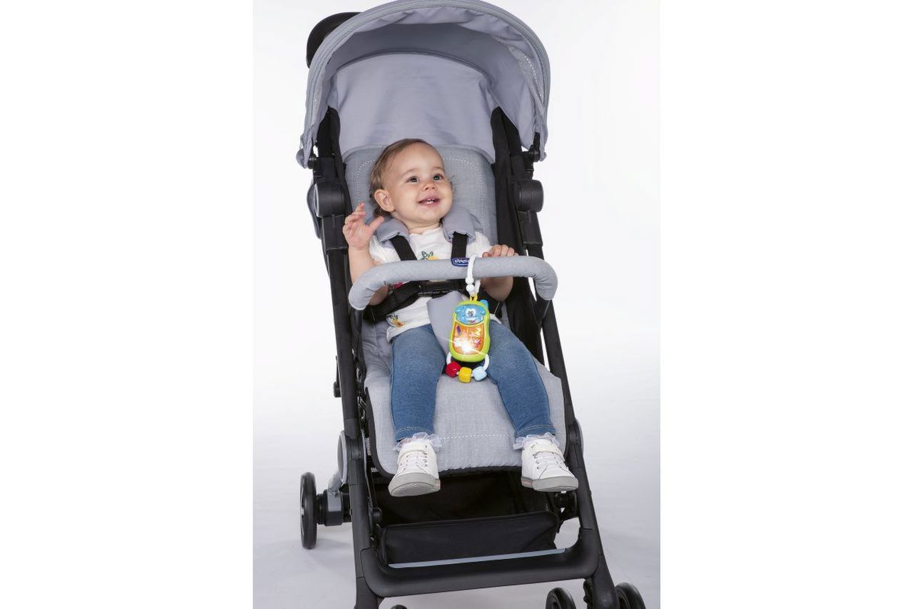 Carrinho de bebé preto com criança e brinquedo colorido