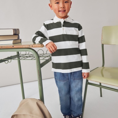 Camisola de riscas branca e verde escuro e calças de ganga num ambiente escolar