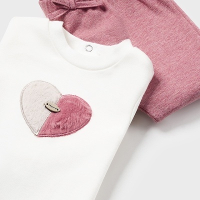 Conjunto de roupa para bebé com camisola branca e calças rosa.