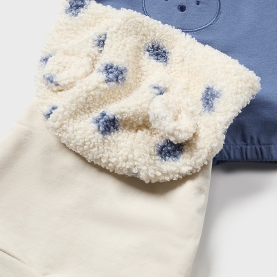 Conjunto de roupa infantil com padrão de urso e texturas variadas em azul, creme e branco