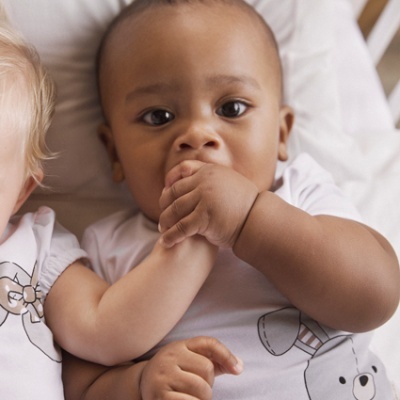 Bebés deitados lado a lado com t-shirts brancas estampadas