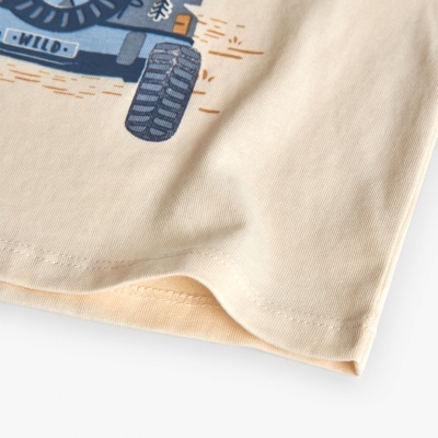 Parte inferior de t-shirt bege com impressão de veículo azul e palavra WILD