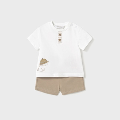 Conjunto de roupa para bebé com camisola branca e calções beje.