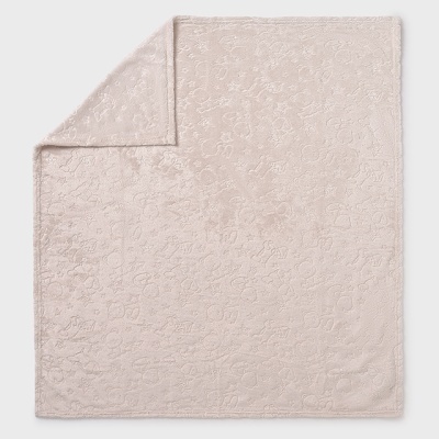 Colcha ou manta rosada clara com padrão floral em relevo e canto dobrado